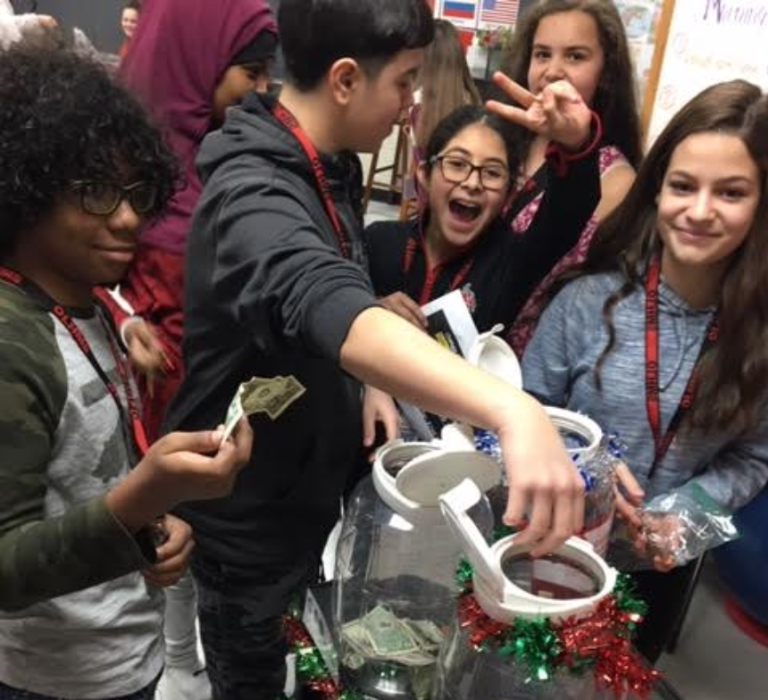 A group of students work to fill their class change jar during passing periods.