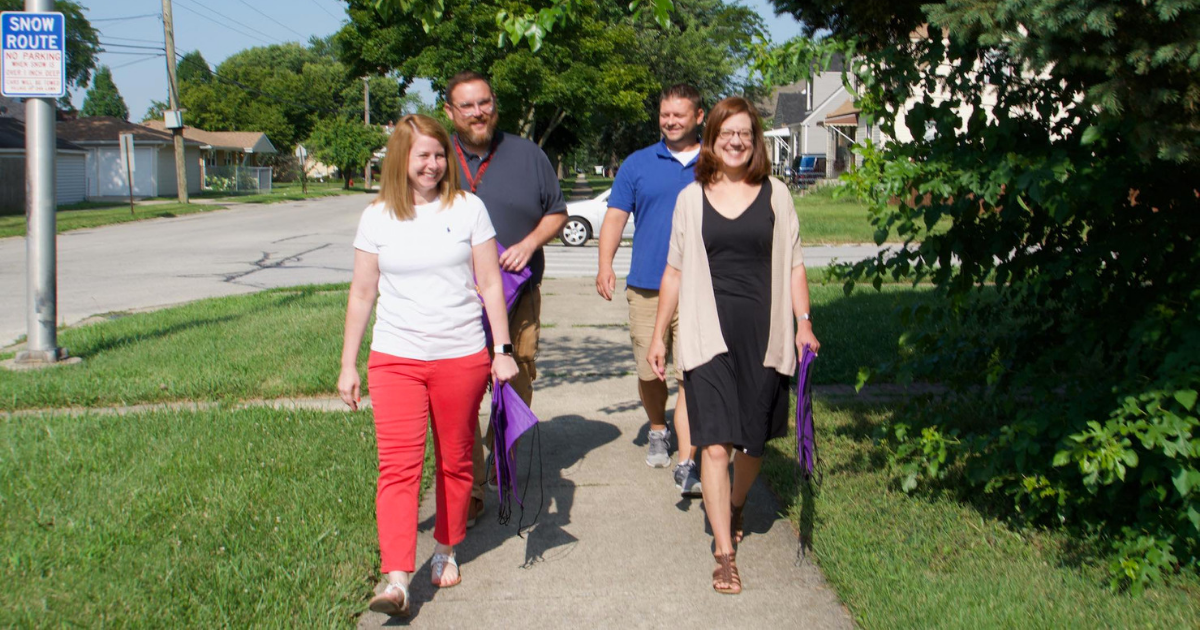 Megan Monroy, Joe Macchia, John Wawczak, and Susan Whited walk around the neighborhood welcoming families to Covington 